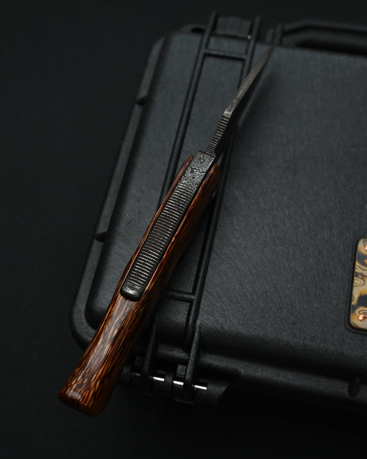 Detailed view of the one-piece natural wood handle on a Kazushi Machida handmade Higonokami-style knife, highlighting its rich grain.