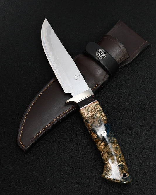 Full view of Nishida Hamono custom fixed blade outdoor knife with a 110 mm forged layered Damascus blade and handcrafted handle.