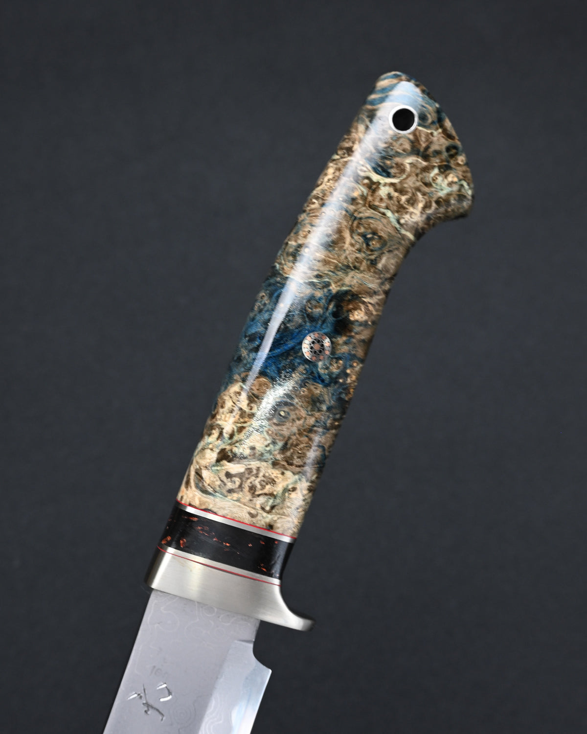 Detailed view of the Nishida Hamono custom knife handle combining stabilized burl wood, bronze, and resin.