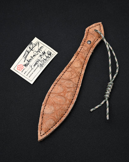 Sunizumi Shoten × Wtopia desert crocodile leather EDC paddle featuring genuine crocodile leather, an internal steel plate, bronze and silver Sunizumi emblem, and 550 paracord lanyard, made in Japan